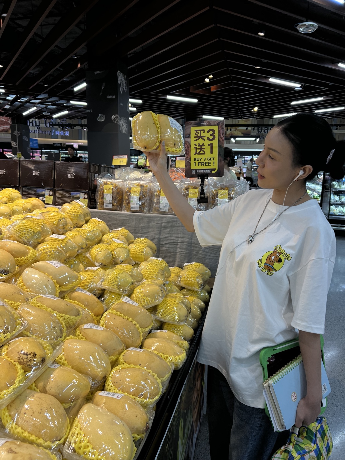 マンゴー売り場で商品を手に取る女性